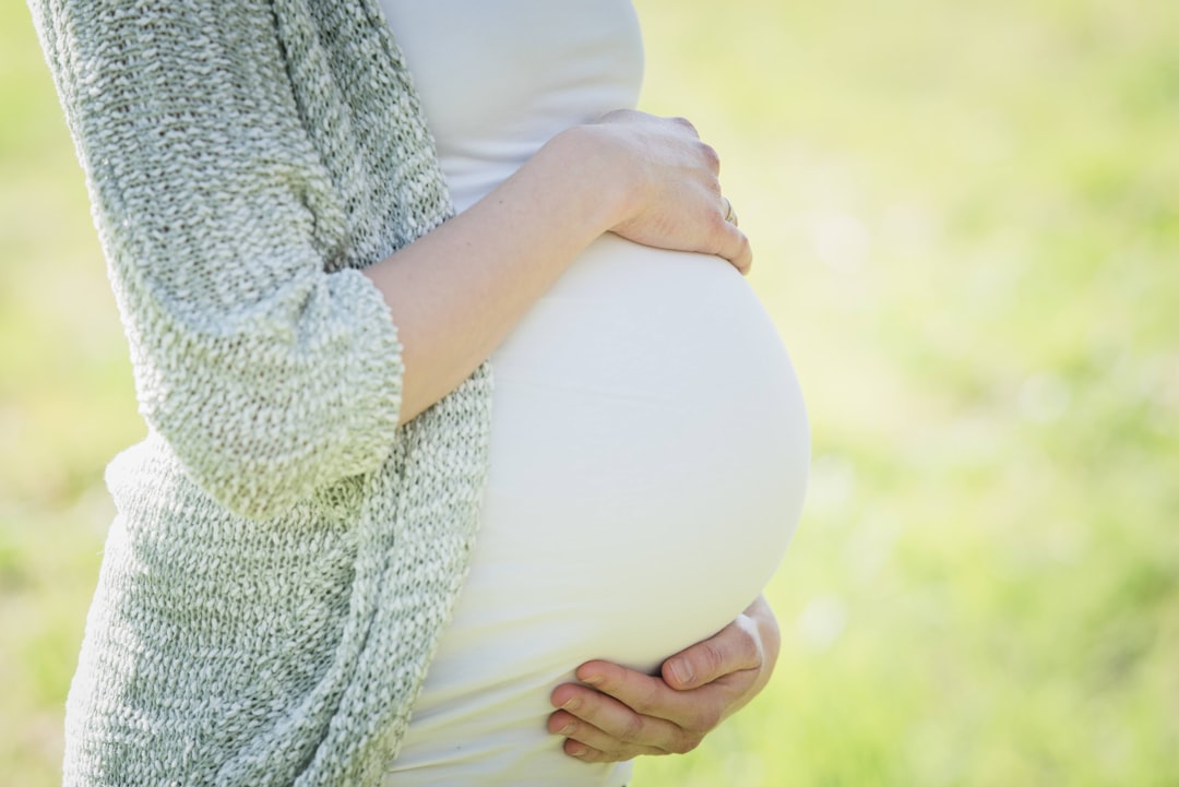 A pregnant woman holding her belly in her hands