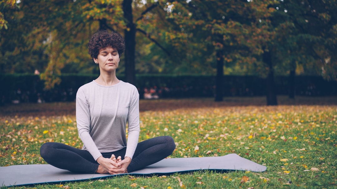 Woman meditating in a park on an autumn day